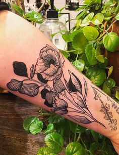 a woman's arm with a flower tattoo on the left side of her arm