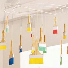 a room filled with lots of different colored paint brushes hanging from the ceiling