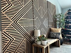 a living room with black and white wallpaper, potted plants and a wooden bench