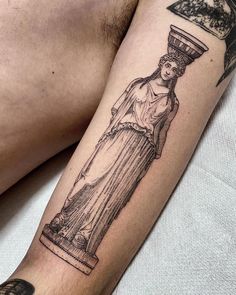 a man's arm with a statue tattoo on it