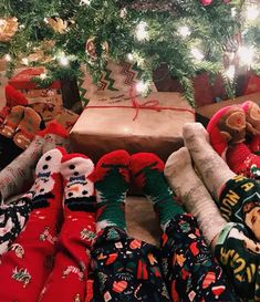 christmas presents under the tree with teddy bears and stockings on them, all wrapped up