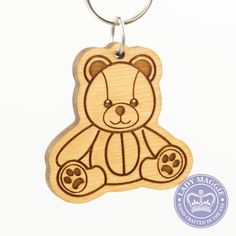 a wooden keychain with a teddy bear on it