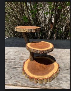 three tiered tree slice stand on top of a wooden table