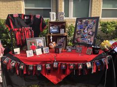 a table covered with pictures and memorabilia in front of a building