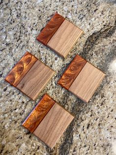 four wooden coasters sitting on top of a granite counter