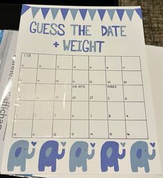 a calendar with blue elephants on it sitting on top of a table next to a laptop