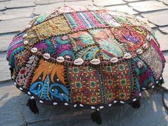 a colorfully decorated ottoman sitting on top of a stone floor