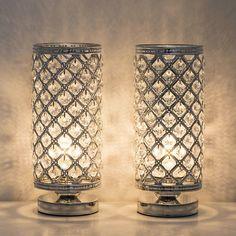 two clear glass candlesticks sitting next to each other on a white counter top