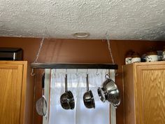 pots and pans hanging from the ceiling in a kitchen