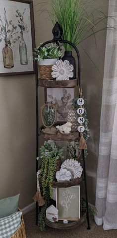 a shelf with plants and pictures on it in the corner of a room next to a window