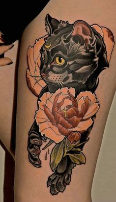 a woman's thigh with a cat and flowers on it