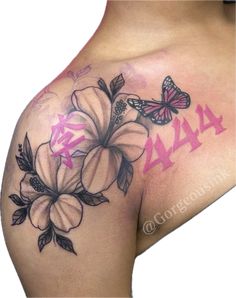 the back of a woman's shoulder with flowers and butterflies on it