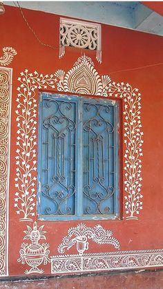 an ornately painted wall with two blue doors