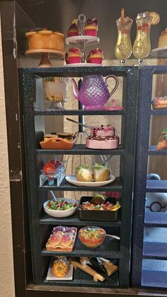 a display case filled with lots of different types of cakes and desserts on shelves