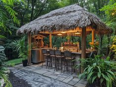 a tiki bar in the middle of a tropical garden