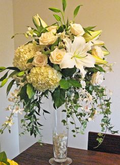 a vase filled with white flowers on top of a wooden table