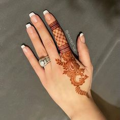 a woman's hand with henna tattoos on it