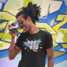 "Take me back to the best decade since the 80s! Everything was better in the 90s. Retro 90s Shirt | Retro Shirt | 90s Kid Shirt | Nostalgia Shirt | Best Of The 90s Shirt | 90s Kid Tee This t-shirt puts a new spin on casual comfort. Made from very soft materials, this tee is 100% cotton for solid colors. Heather colors and sports grey include polyester. The shoulders have twill tape for improved durability. There are no side seams. The collar is made with ribbed knitting to prevent curling damage.   * Unisex Basic Softstyle T-Shirt - Gildan 64000* * 100% cotton (fiber content may vary for different colors) * 4.5 oz/yd² (153 g/m²) * Pre-shrunk * Shoulder-to-shoulder taping * Eurofit * Tear-away label * Runs true to size * Quarter-turned to avoid crease down the center + Please check size cha 90s Inspired Letter Print T-shirt For Streetwear, 90s Inspired Short Sleeve Screen Print T-shirt, 90s Inspired Streetwear T-shirt With Screen Print, 90s Inspired Streetwear Tops, 90s Style Screen Print T-shirt, 90s Style T-shirt With Text Print For Fans, 90s Inspired Graphic Print T-shirt For Fans, 90s Style Funny Print T-shirt For Streetwear, 90s Inspired T-shirt With Graphic Print For Fans