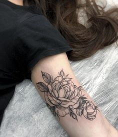 a black and white rose tattoo on the arm