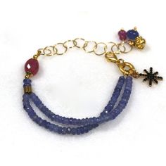 Glittering, vibrantly hued genuine polished natural periwinkle hued tanzanite, one of the rarest and most prized of all gemstones, sparkles on this strand in a beautiful bright striking splash of color! A plump faceted pink sapphire accents the side of the wrist. 14k gold fill chain and colorful drop embellishments add a little chic bling. l Fine Jewelry Blue Amethyst Jewelry, Fine Jewelry In Blue Amethyst, Blue Faceted Amethyst Jewelry, Faceted Blue Amethyst Jewelry, Blue Tanzanite Gemstone Bracelets, Blue Tanzanite Bracelet Jewelry, Blue Amethyst Beaded Bracelets As Gift, Blue Amethyst Beaded Bracelets For Gift, Handmade Blue Amethyst Bracelets