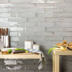 a table with bread and other food on it in front of a gray brick wall