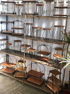 several shelves with wooden chairs on them in a room