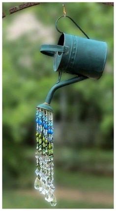 a blue bird feeder hanging from a tree branch