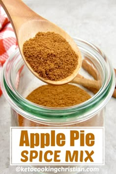 an apple pie spice mix in a glass jar with a wooden spoon and cinnamon sticks