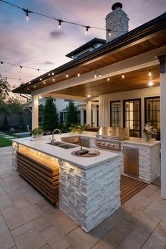 an outdoor kitchen is lit up at night