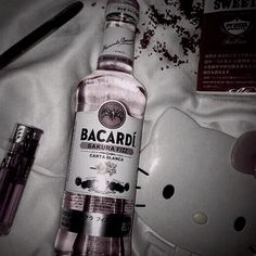 a bottle of bacardi vodka next to a hello kitty mouse