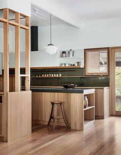 a kitchen with wooden floors and black counter tops