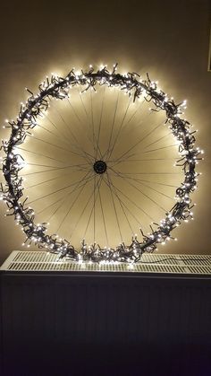 a large wheel with lots of lights on it's side in front of a wall