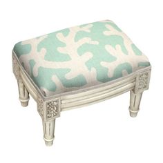 a white bench with a blue and white pattern on it's seat cushion is sitting in front of a white background