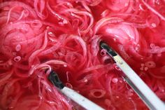 the scissors are being used to cut red onions