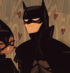 batman and catwoman standing next to each other with hearts on the wall behind them