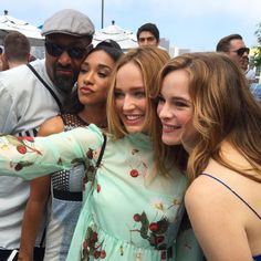 two women and one man are taking a selfie with their friends at an event