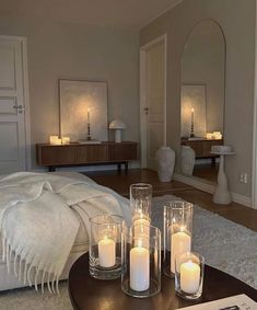 candles sit on a coffee table in front of a mirror