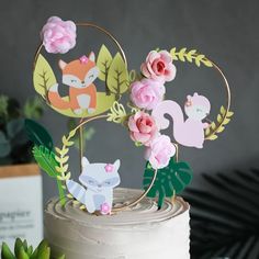 there is a cake decorated with animals and flowers