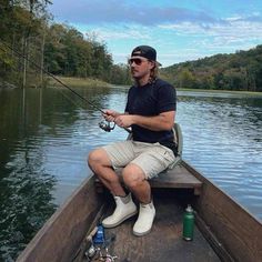 a man sitting in a boat holding a fishing rod