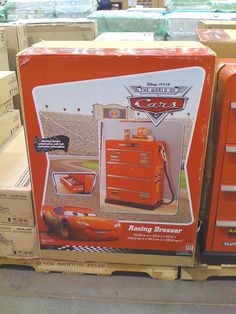 an orange box sitting on top of a pallet in front of some cardboard boxes