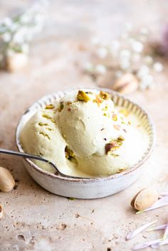 a bowl filled with ice cream next to nuts