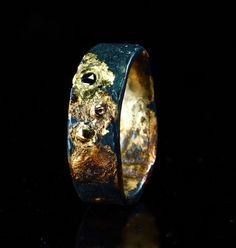 a close up of a ring with gold and black paint on the inside of it