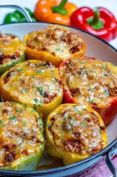 several stuffed peppers in a pan with cheese and seasoning on top, ready to be eaten