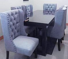 a dining room table and chairs with blue velvet upholstered backrests on them