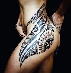 a woman's stomach with an intricate tattoo design on the side, and her lower body