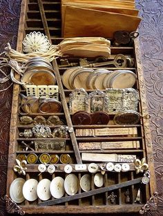 an old wooden drawer filled with lots of different types of buttons and other things in it