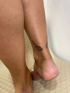 a close up of a person's foot with a tattoo on her left leg