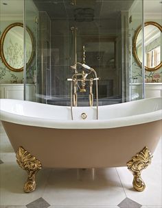 an ornate bathtub sits in the middle of a room with mirrors on the wall