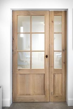 a wooden door with glass panels in a room