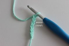 the crochet hook is being used to hold yarn